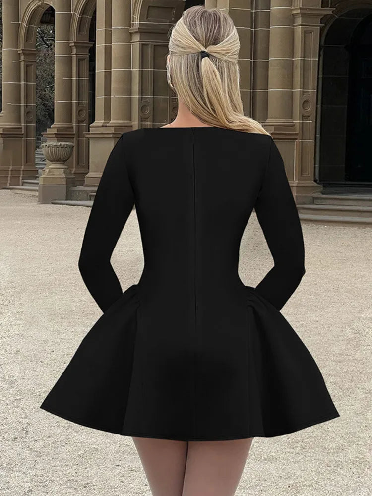 Woman wearing a black long-sleeved mini dress with an O-neck, high-waist A-line silhouette, bodycon fit, and a flowy skirt,