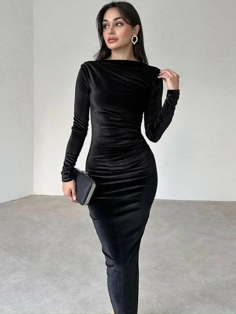 Woman wearing a black Midi Dress in velvet, featuring an O-neckline, long sleeves, high waist, and folded detailing with a mid-calf length 